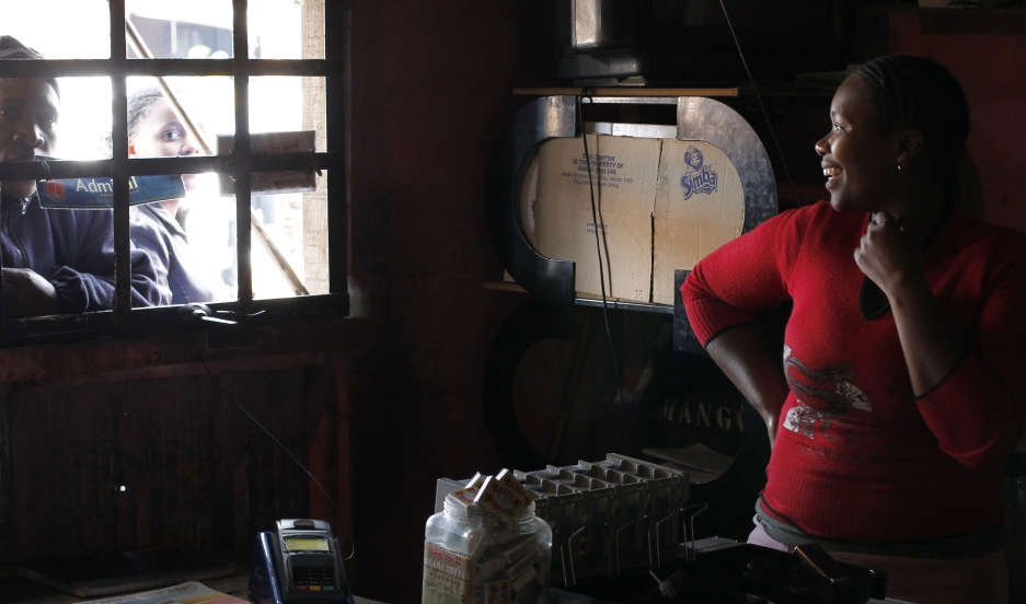 Trader Nono Dawane greets customers at her shop selling cigarettes and cold drinks, in Cape Town's Khayelitsha township.